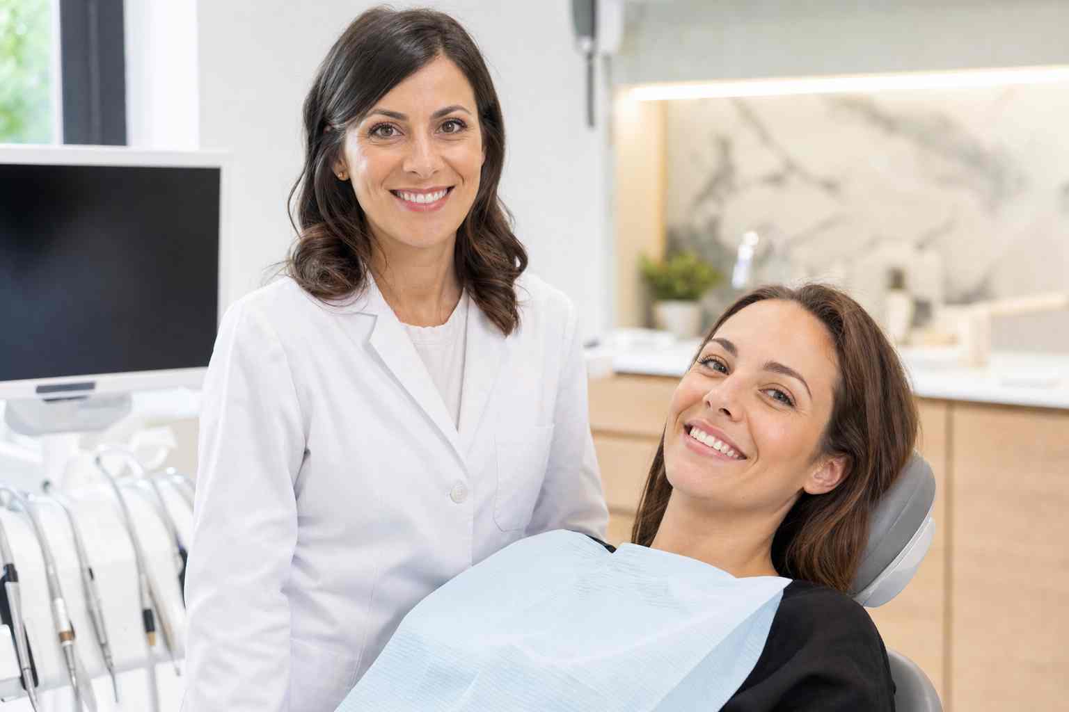 Врач-ортопед и пациентка с улыбкой в кресле клиники Estetic Dent в Туле